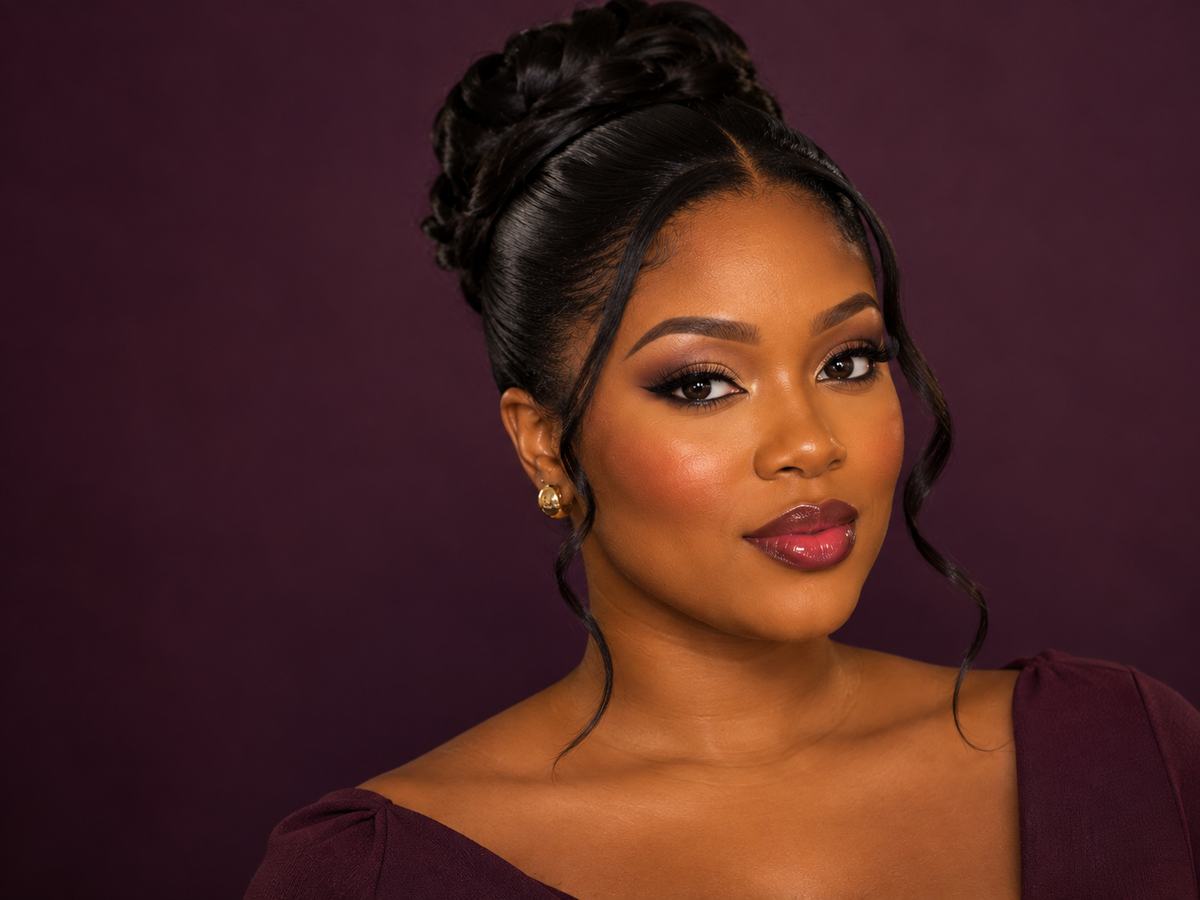 A woman with polished full-glam makeup and a styled updo